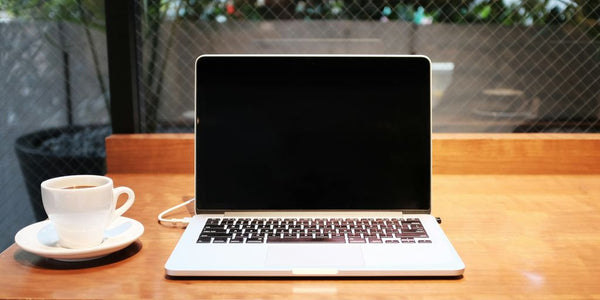 laptop computer beside coffee mug