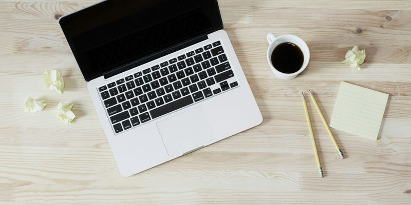 turned off MacBook Pro beside white ceramic mug filled with coffee