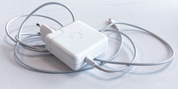 white apple charging adapter on white table