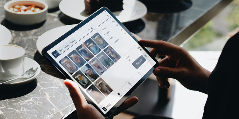 A person sitting at a table with a tablet