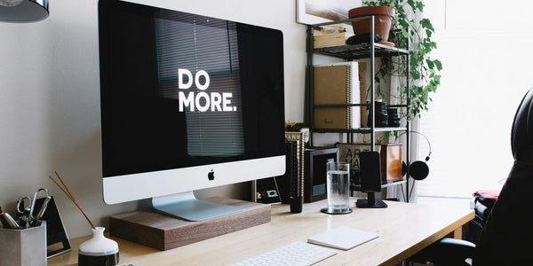 silver iMac with keyboard and trackpad inside room